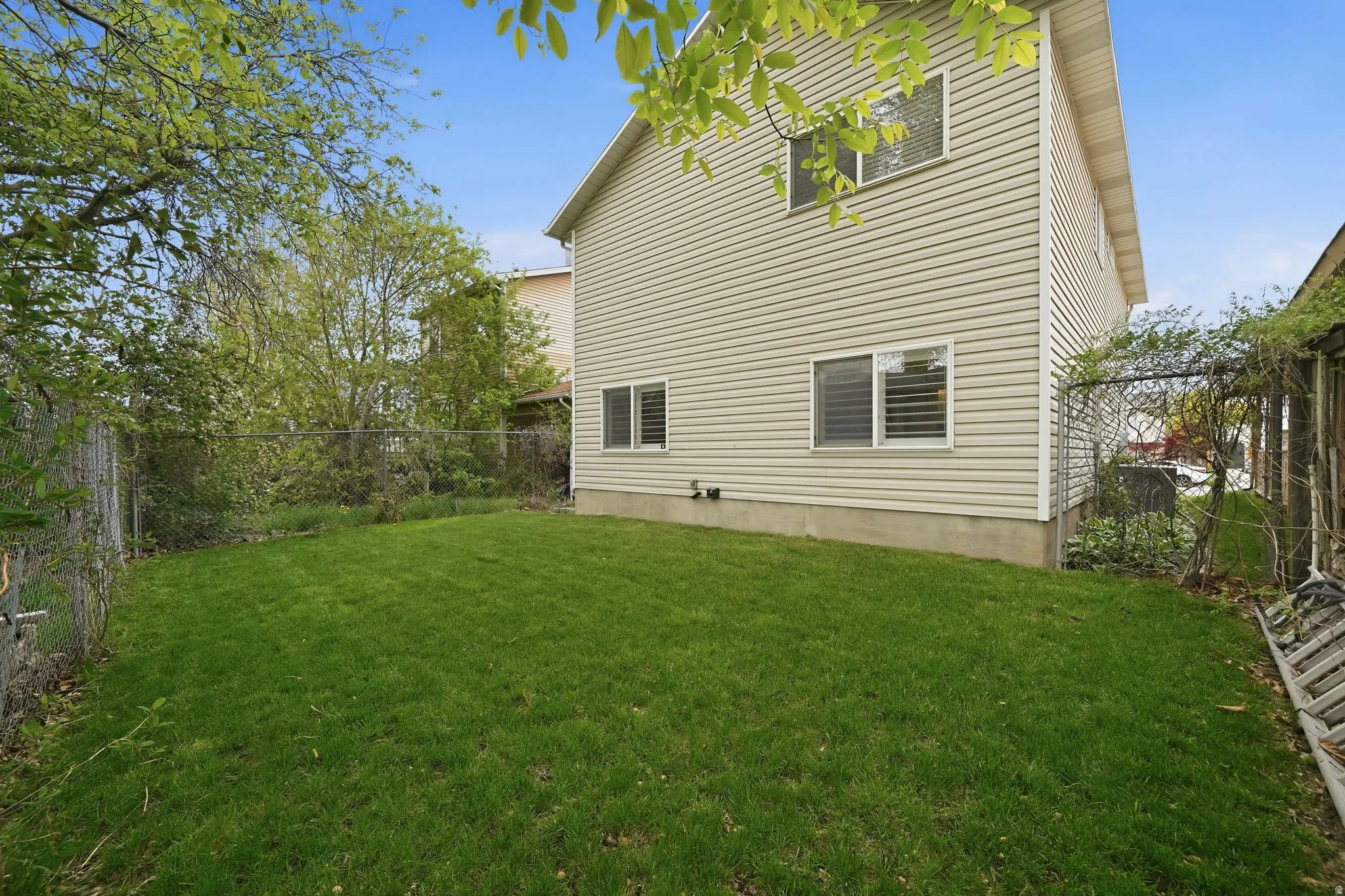 Rear view of house featuring a fenced backyard