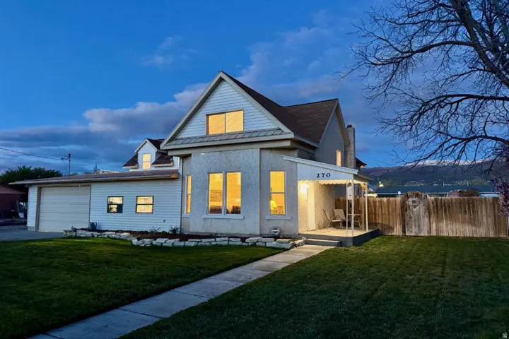 Back of house with a garage and stucco siding