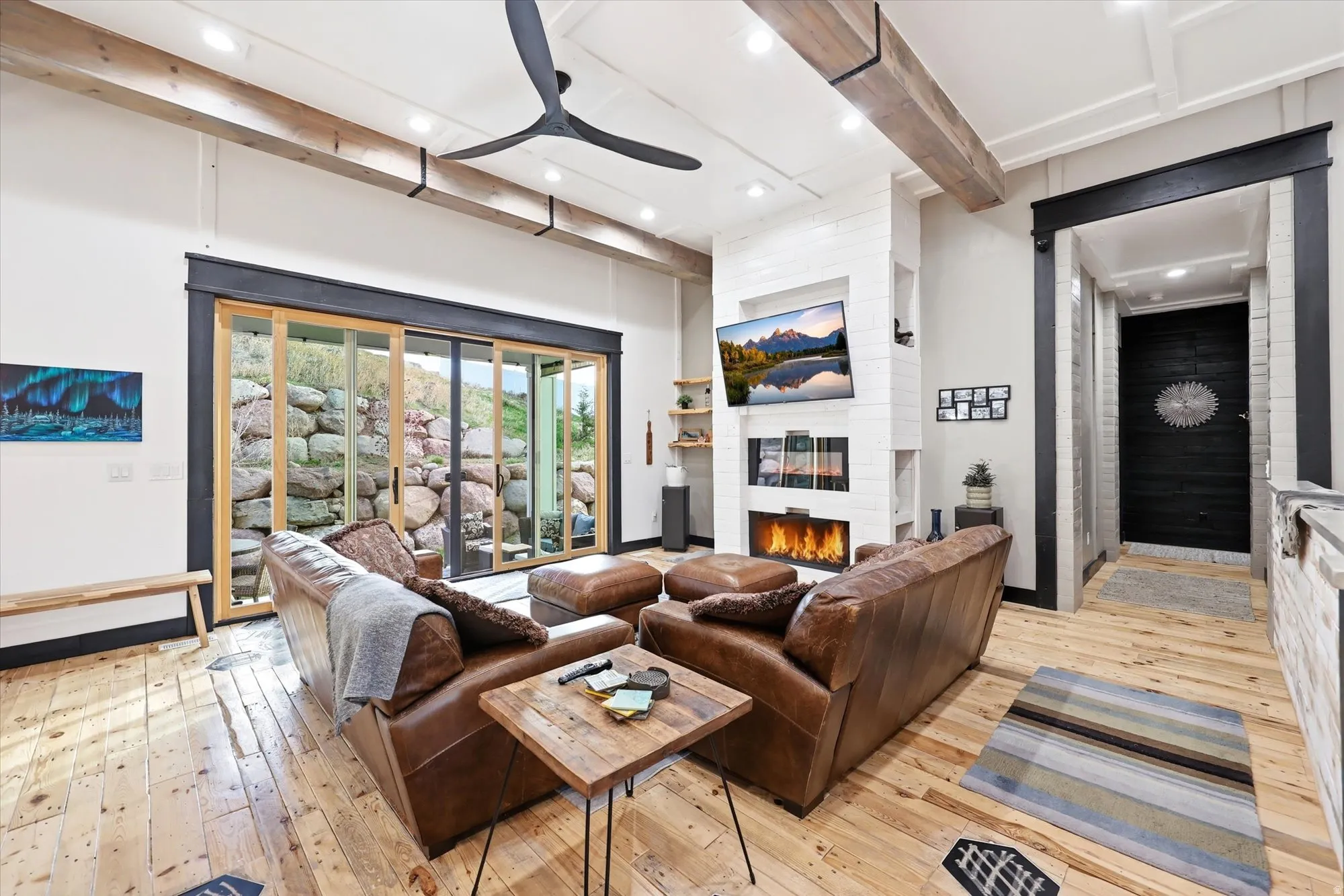 Living room featuring beamed ceiling, a fireplace, light wood-style flooring, recessed lighting, and ceiling fan