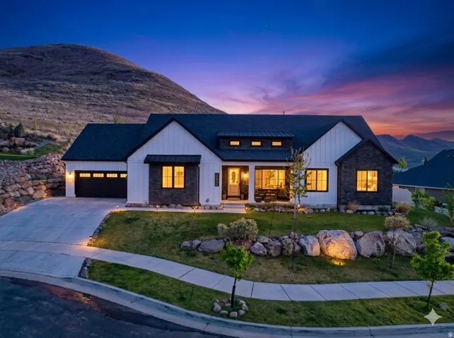 View of front of house featuring board and batten siding, driveway, a porch, a garage, and a lawn