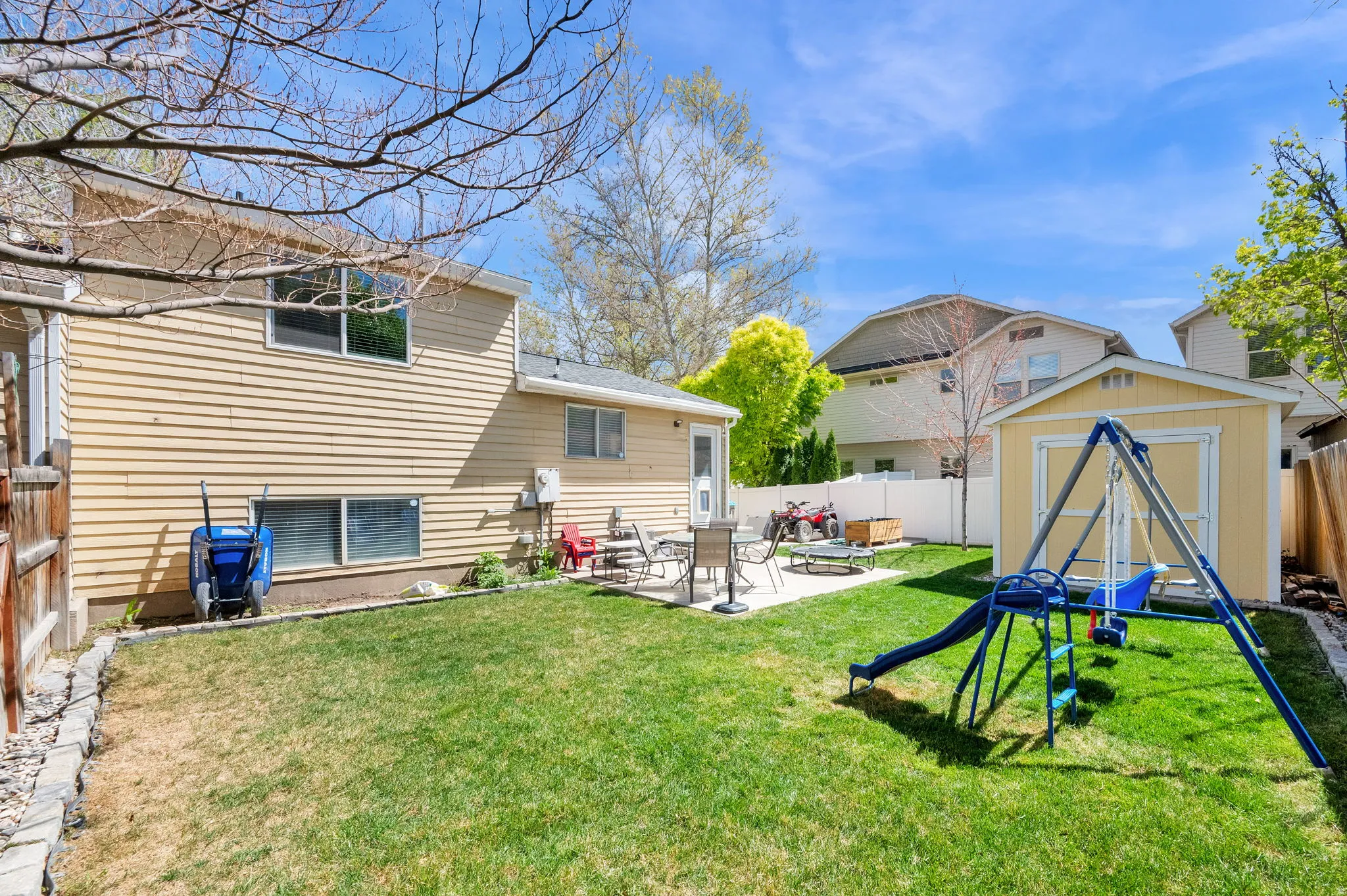Rear view of house featuring a fenced backyard, a storage shed, and a patio area