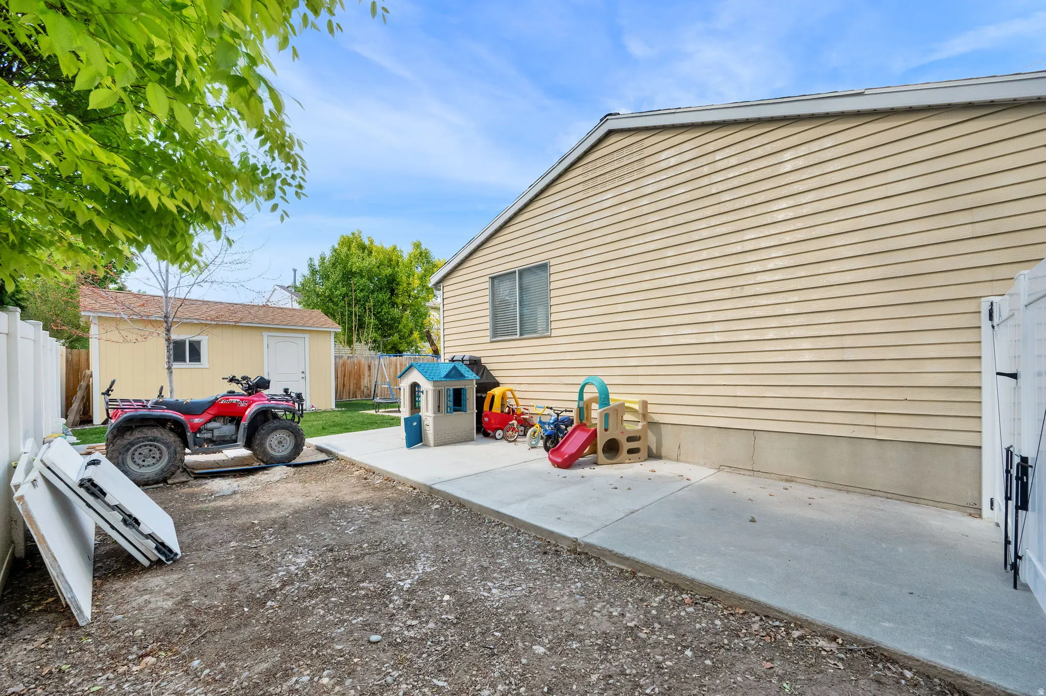 Fenced backyard with a patio and an outbuilding