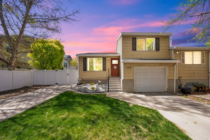 Tri-level home featuring a gate, driveway, and a garage