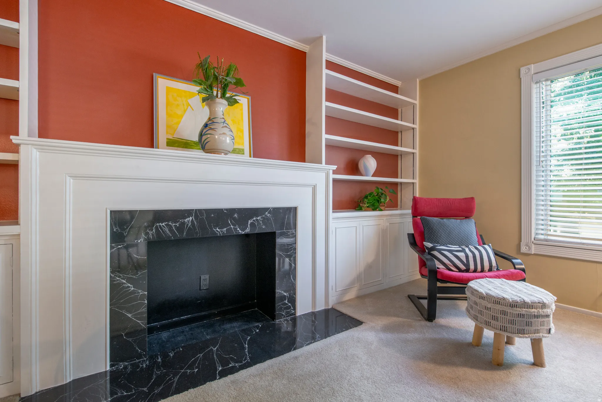 Living area with built in features, carpet flooring, a high end fireplace, and ornamental molding