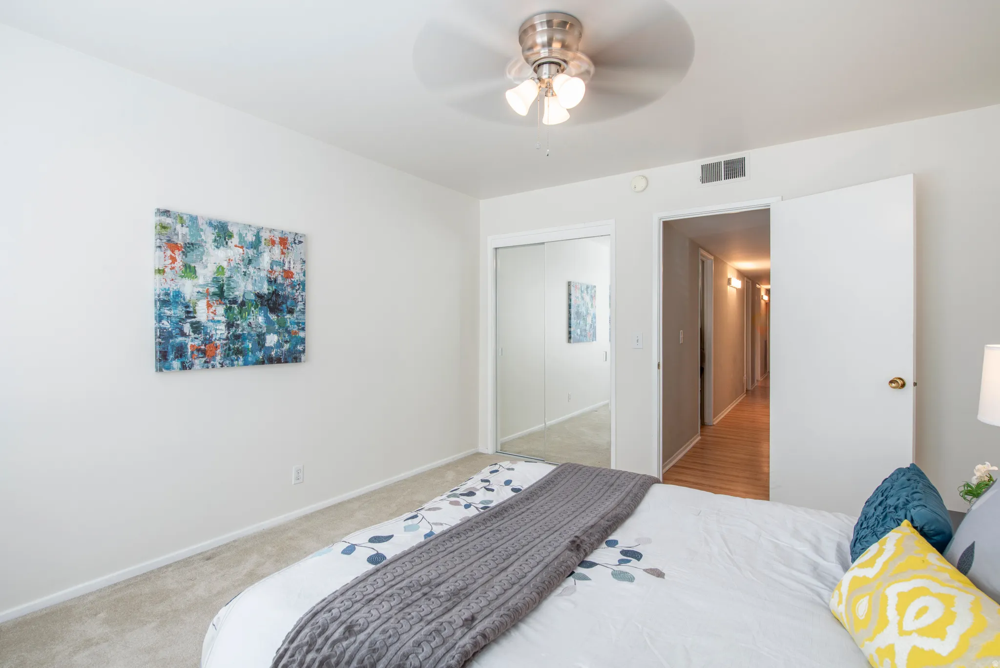 Bedroom featuring ceiling fan, a closet, and light carpet