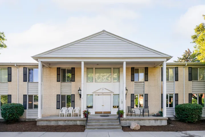 View of front of house featuring a porch and brick siding