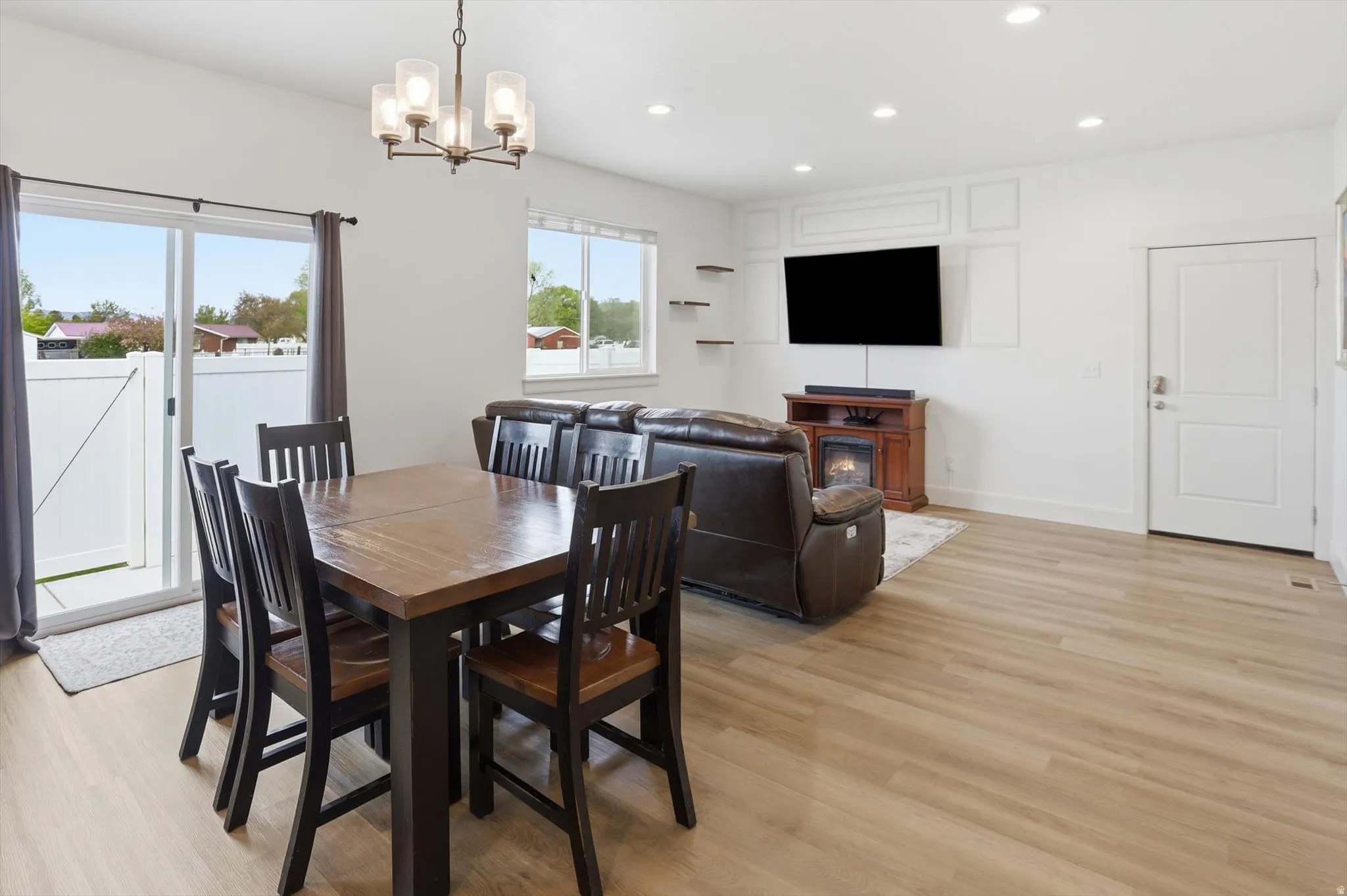 Dining area with light wood-style floors and hanging lights