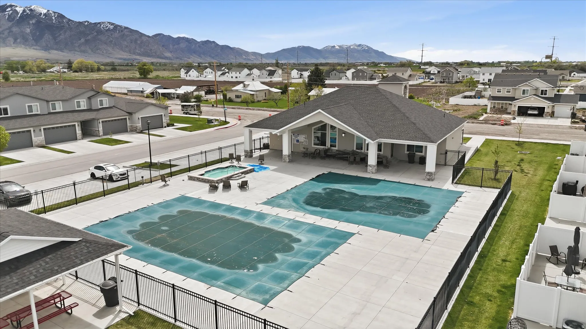View of pool with a residential view, patio surround, a mountain view, and an in-ground hot tub