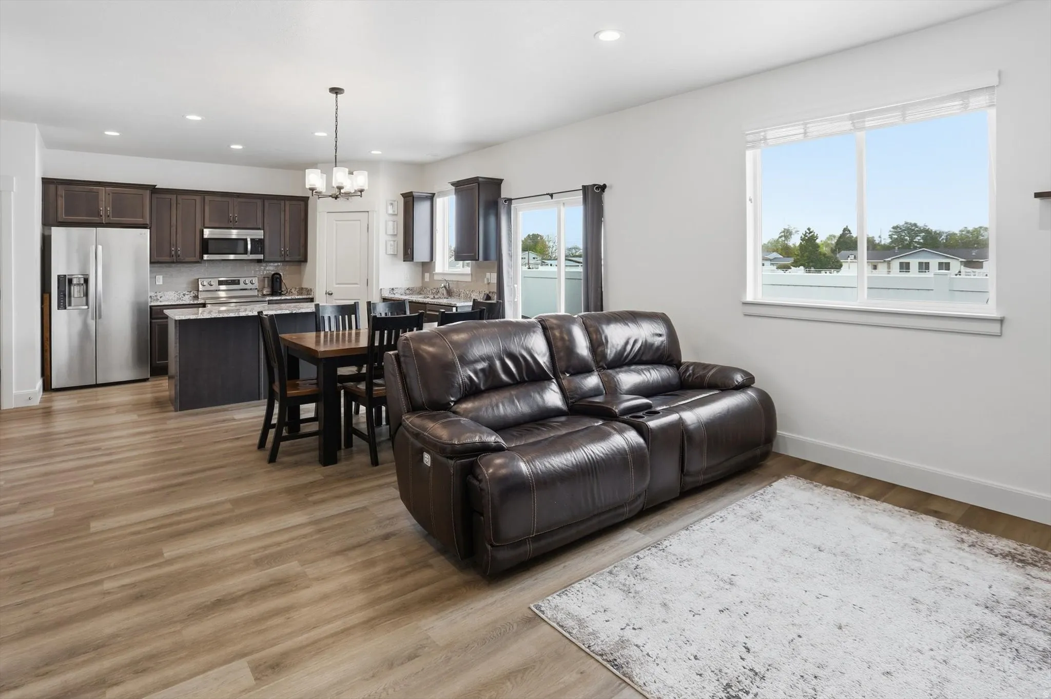 Living area featuring suspended lighting and light wood-style floors