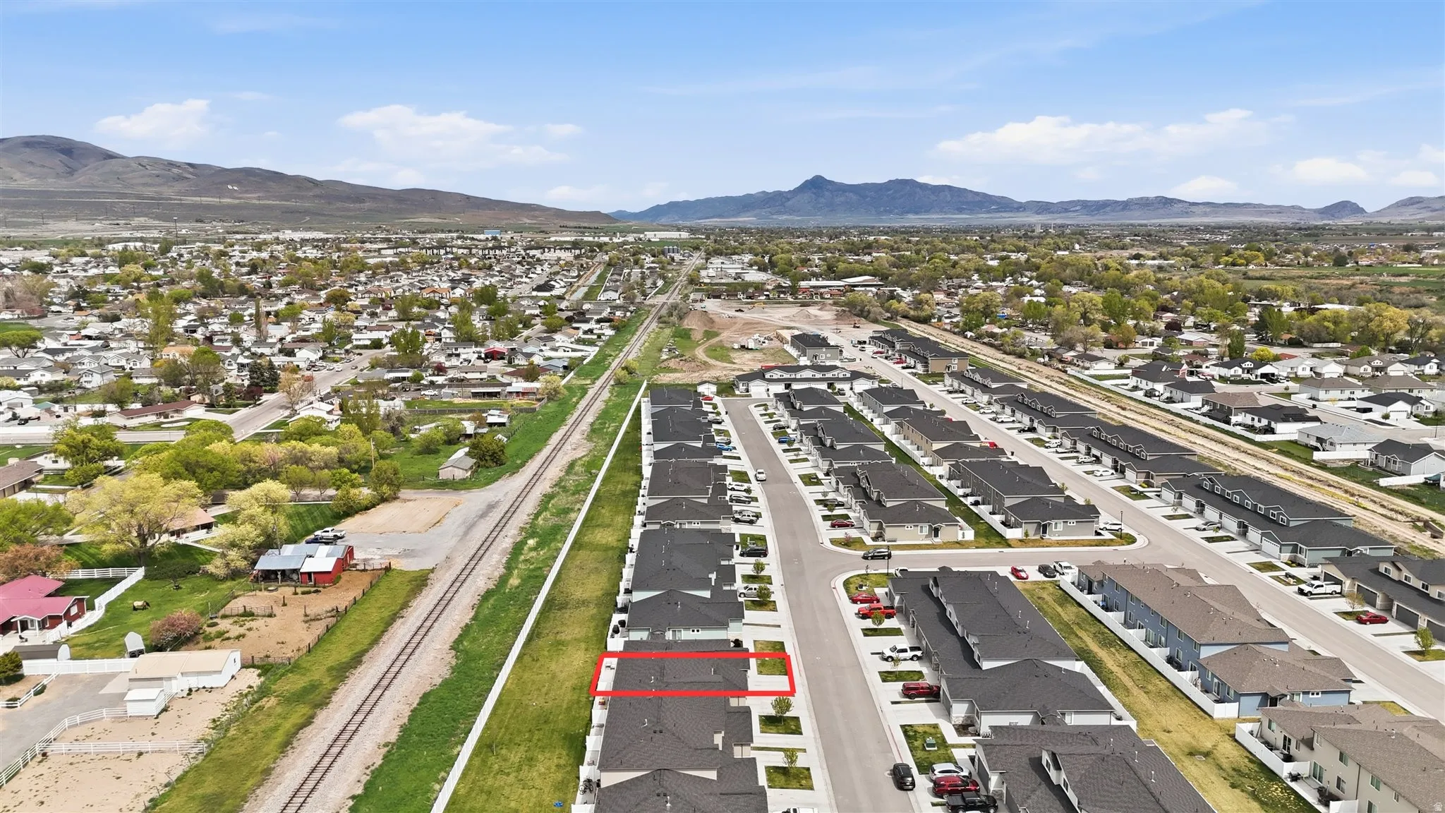 Aerial view of property's location featuring property boundaries highlighted, nearby suburban area, and mountains