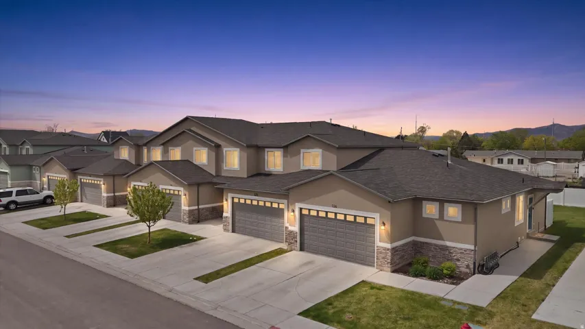 Traditional-style home featuring stucco siding, stone siding, concrete driveway, roof with shingles, and a residential view