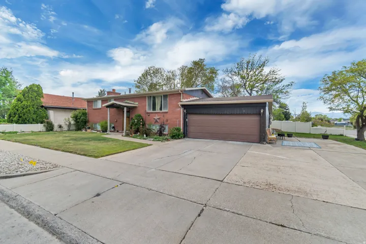 Bi-level home with brick siding, driveway, and a garage