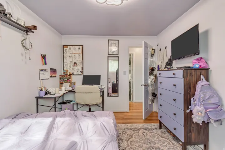 Bedroom featuring light wood finished floors and a desk