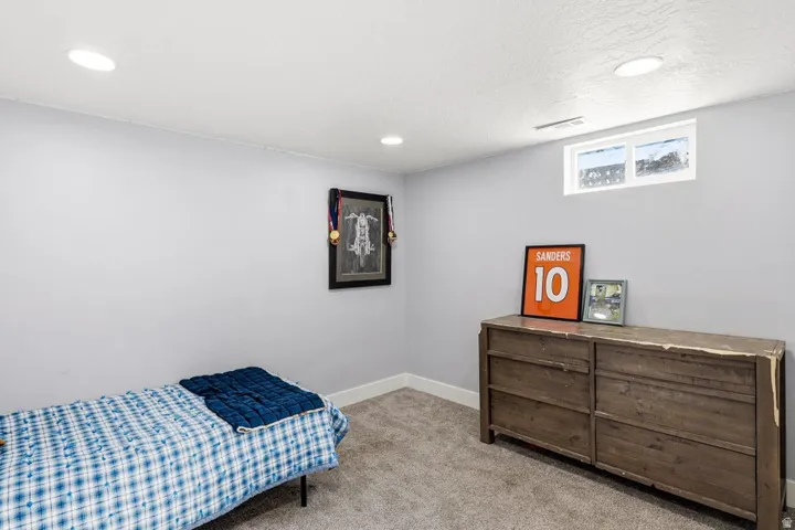 Bedroom with light colored carpet and recessed lighting