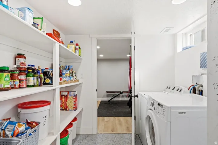 Laundry area with separate washer and dryer and dark speckled floor