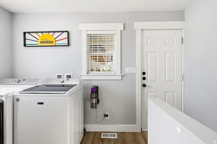 Laundry room featuring light wood-style flooring and washer and clothes dryer