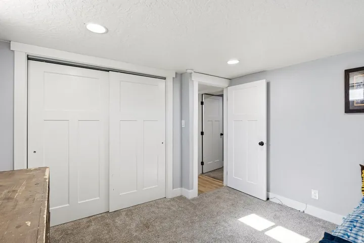 Unfurnished bedroom with light carpet, a closet, recessed lighting, and a textured ceiling