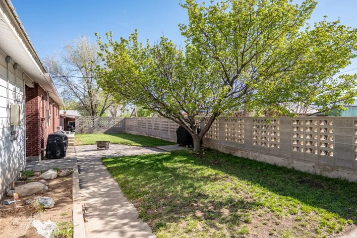 Fenced backyard with a fire pit and a patio
