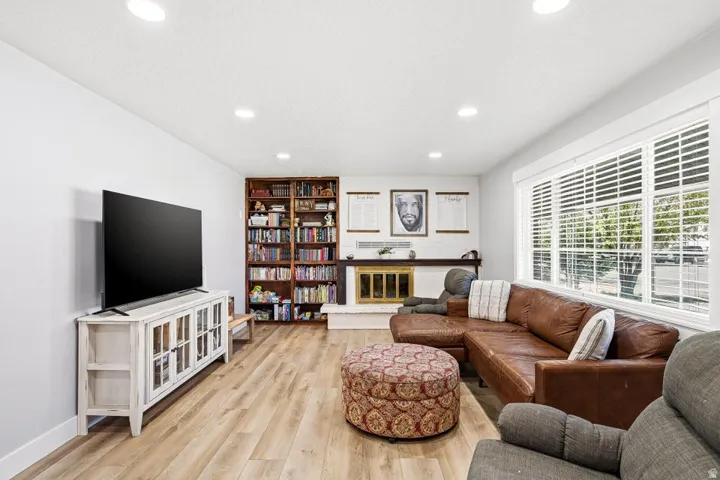 Living area with light wood-style floors, recessed lighting, and built in features