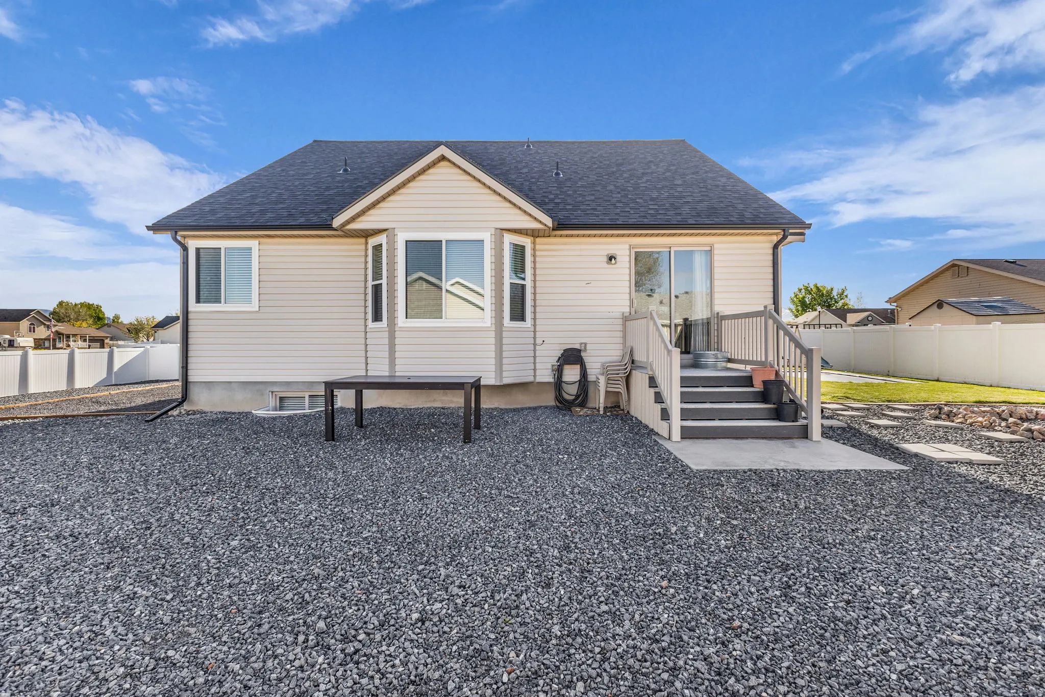 Back of house with a shingled roof and a patio