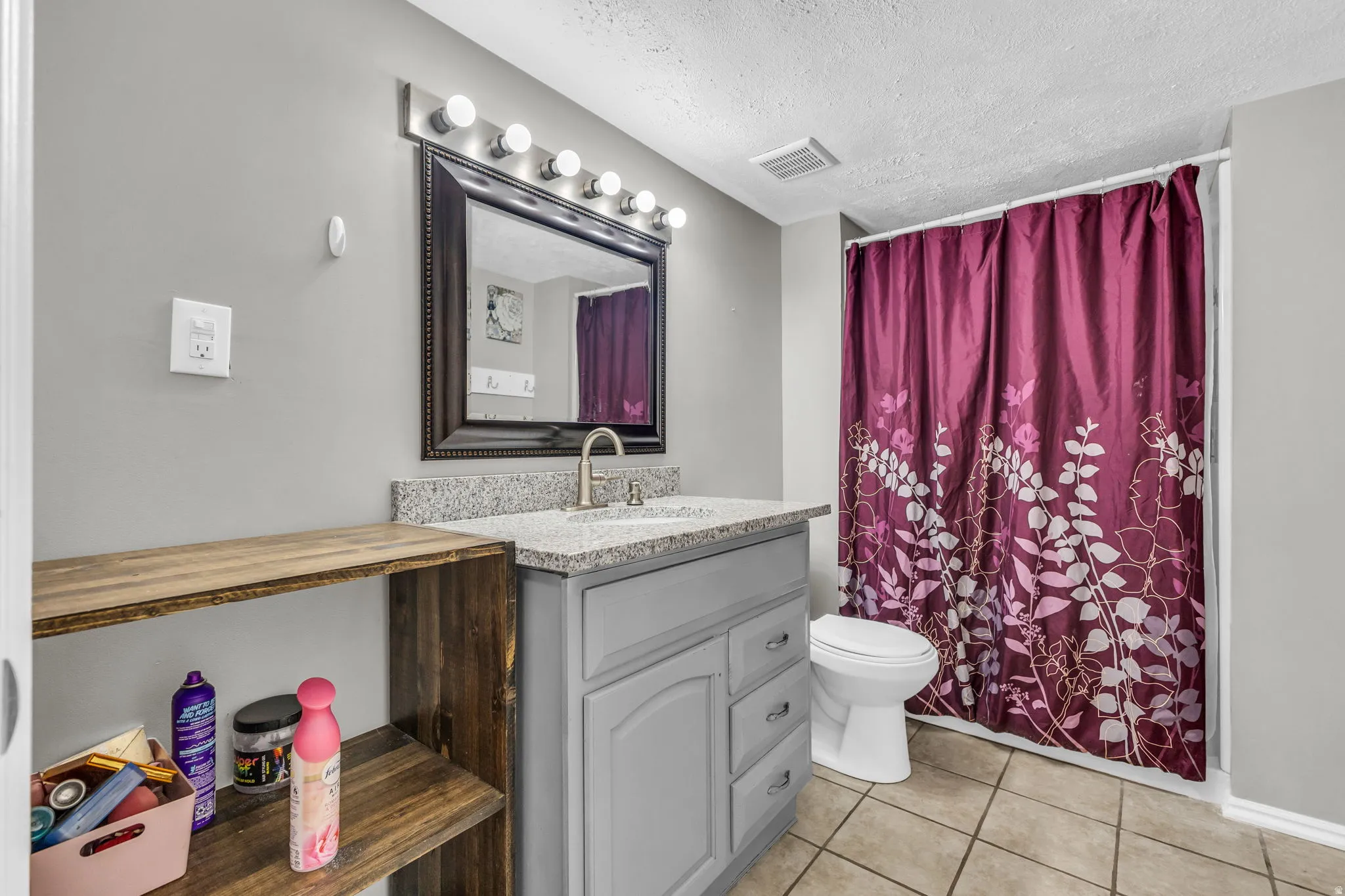 Full bathroom with vanity, a textured ceiling, light tile patterned floors, and shower / tub combo