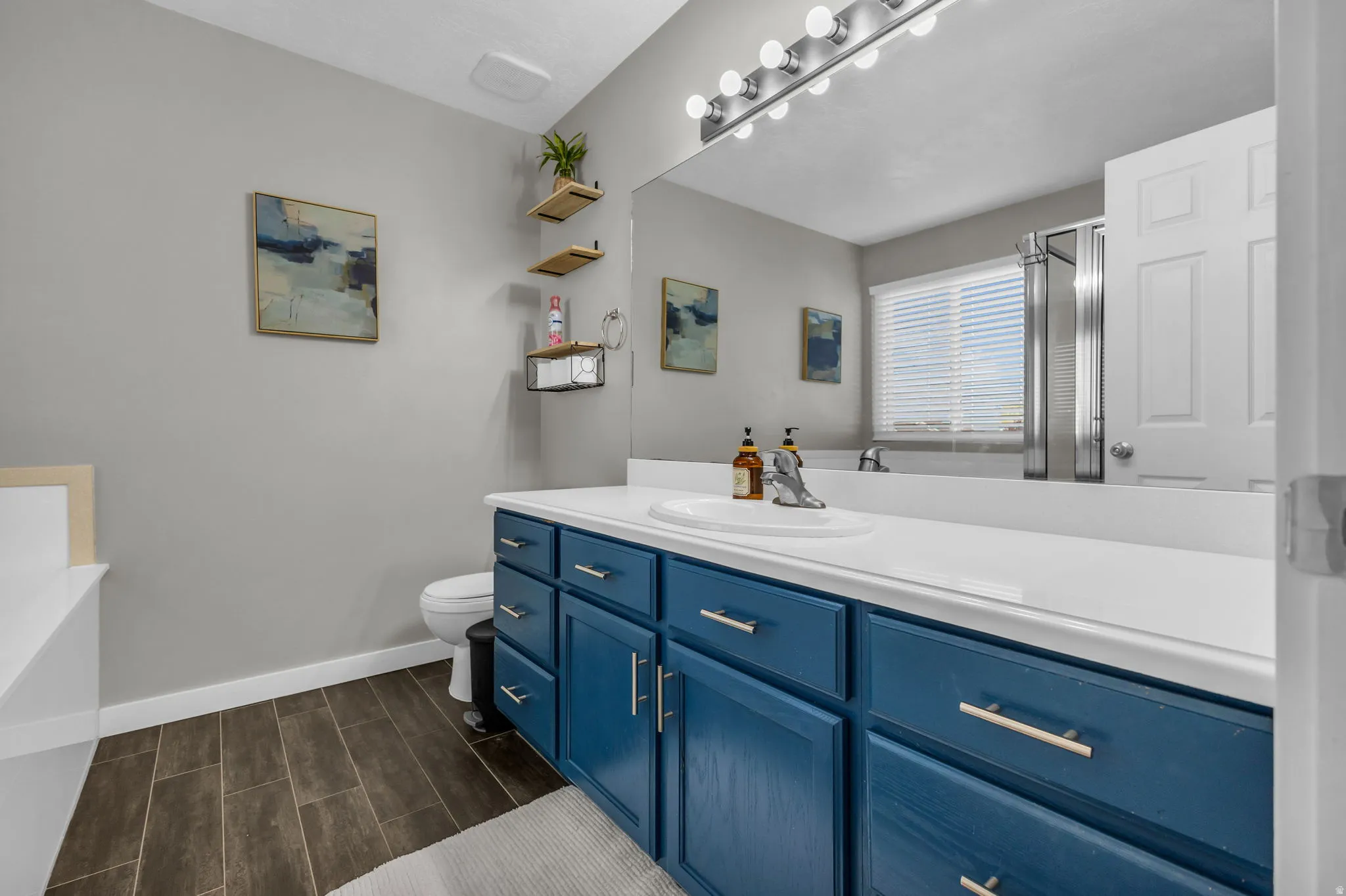 Full bathroom featuring vanity, a garden tub, wood tiled floors, and a shower stall