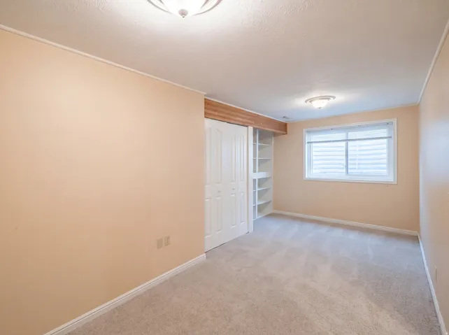 Unfurnished bedroom with light colored carpet, a closet, and a textured ceiling
