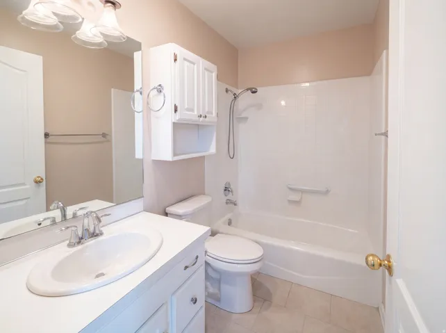 Full bath with vanity, light tile patterned floors, and shower / bathtub combination