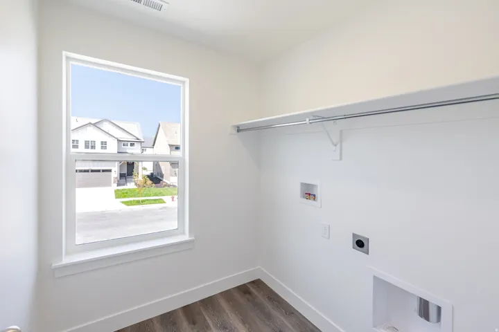 Laundry area featuring a window, built-in shelving, and a hanging rod