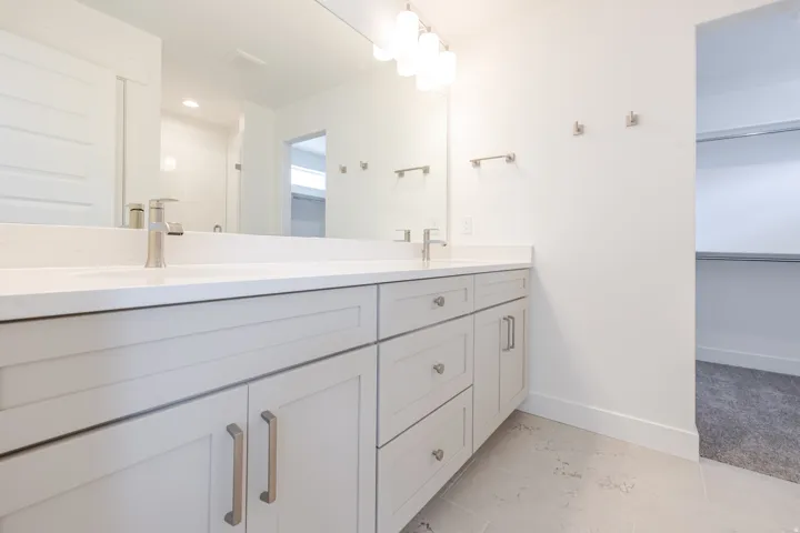 Dual vanity with white countertops and undermount sinks