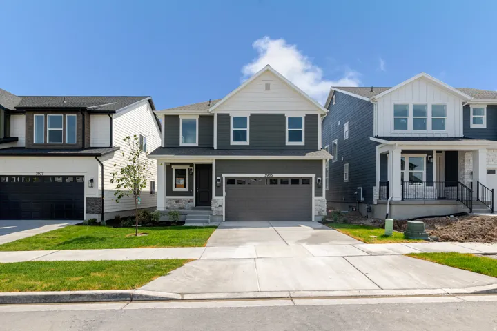 Two-story home with a dark gray exterior, white trim, and a prominent front-facing gable