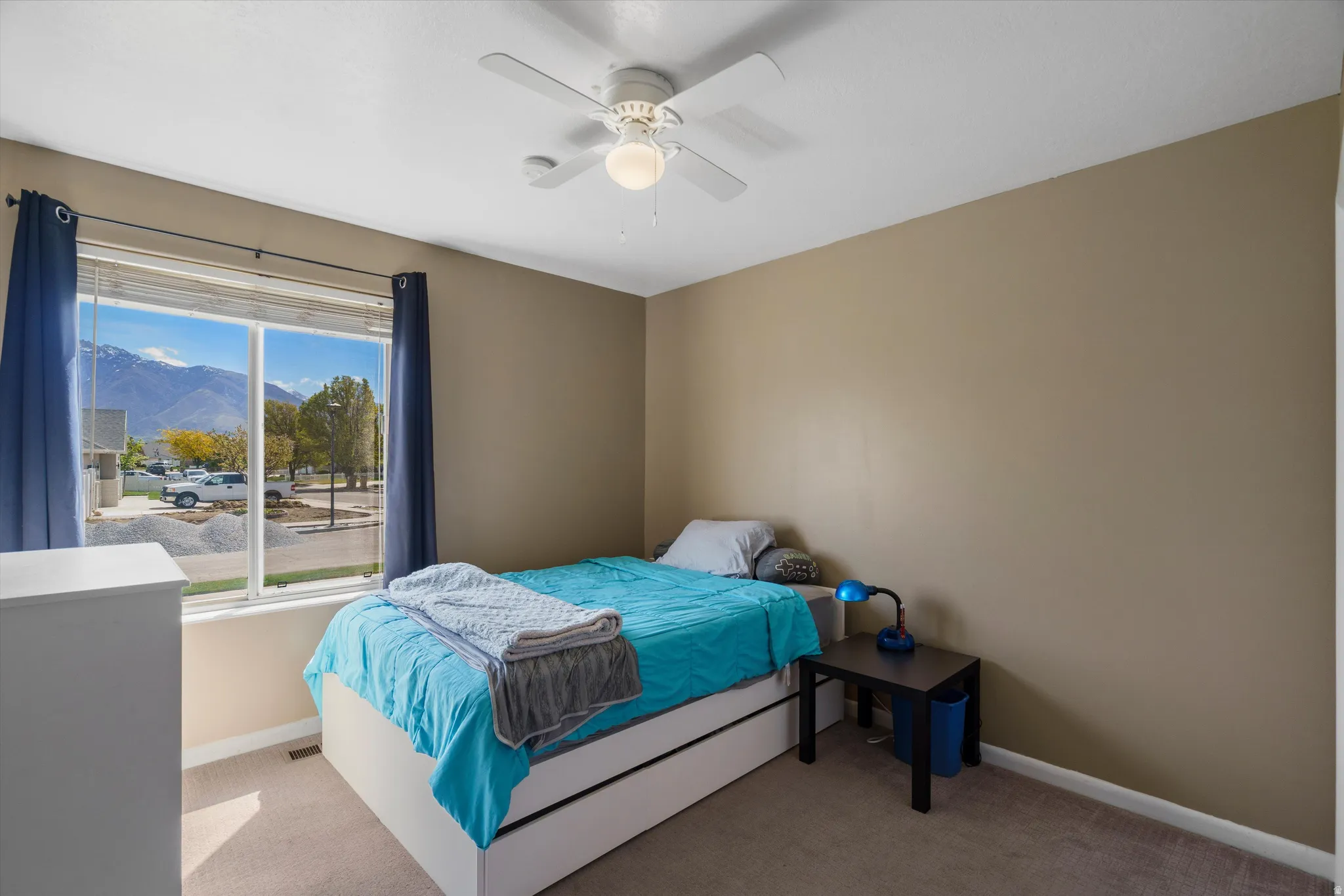 Bedroom featuring a mountain view, light carpet, and ceiling fan