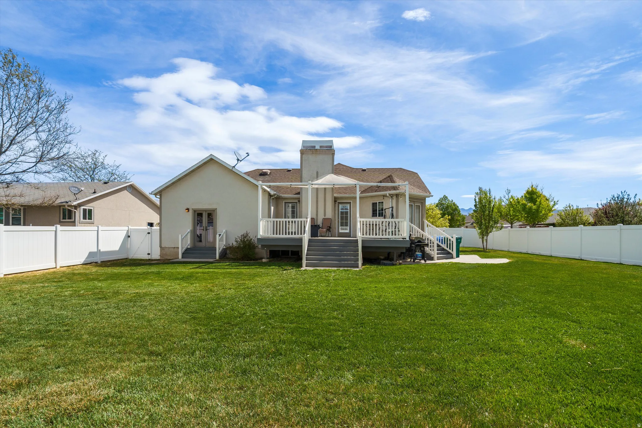 Back of property with a fenced backyard, a chimney, and a gate