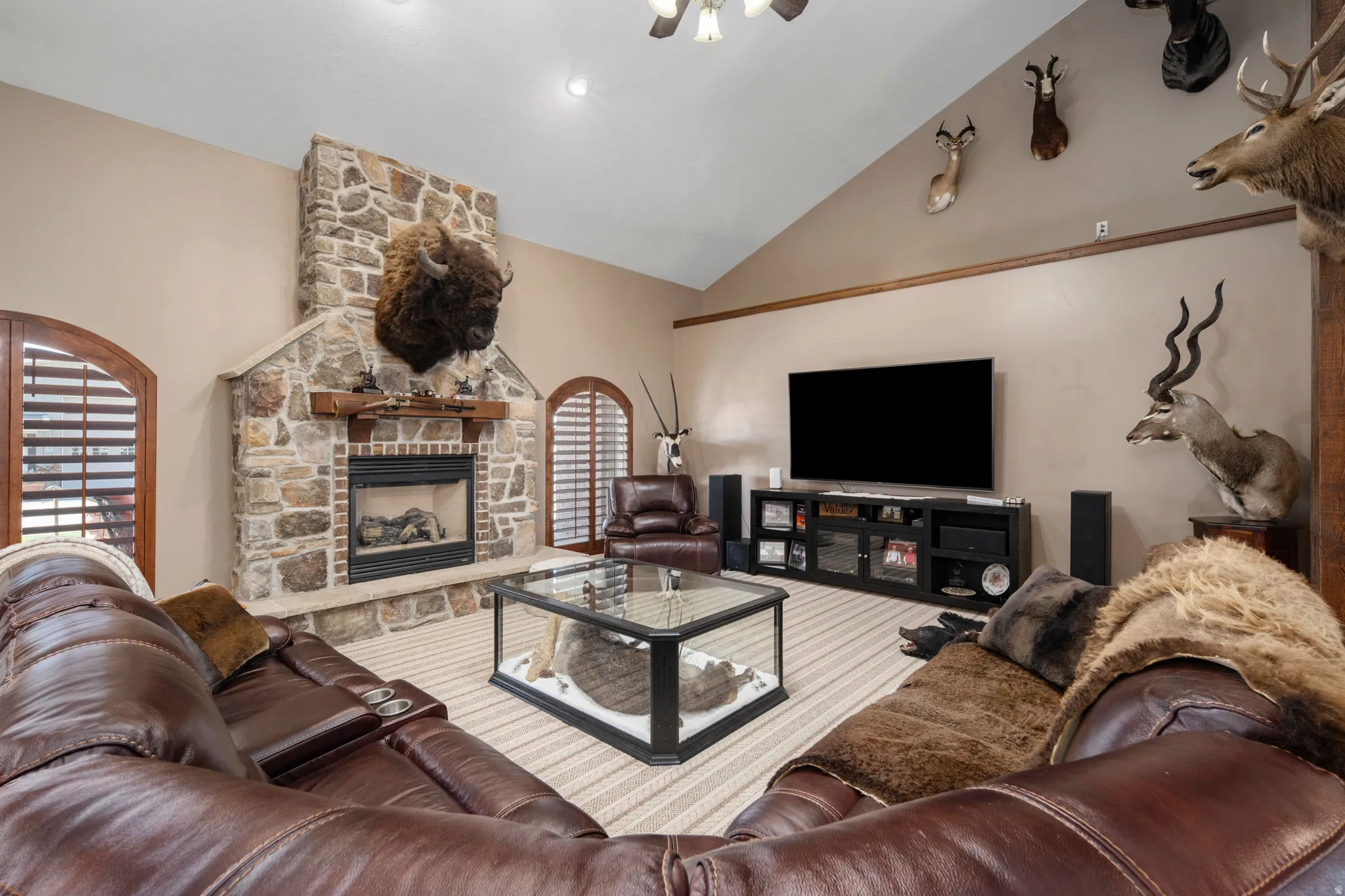 Living area featuring a stone fireplace and lofted ceiling