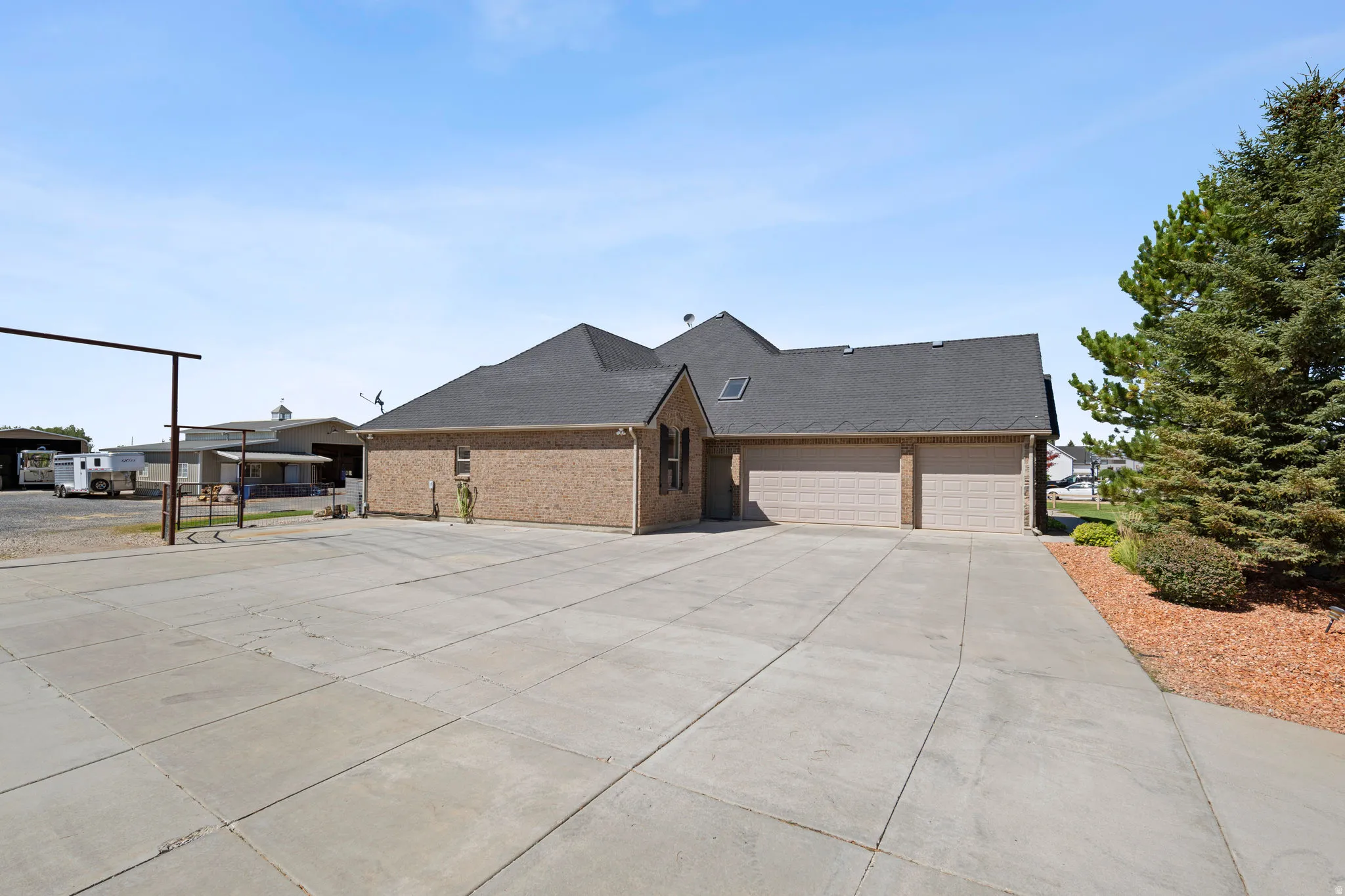 View of front of house with brick siding, driveway, an attached garage, and roof with shingles
