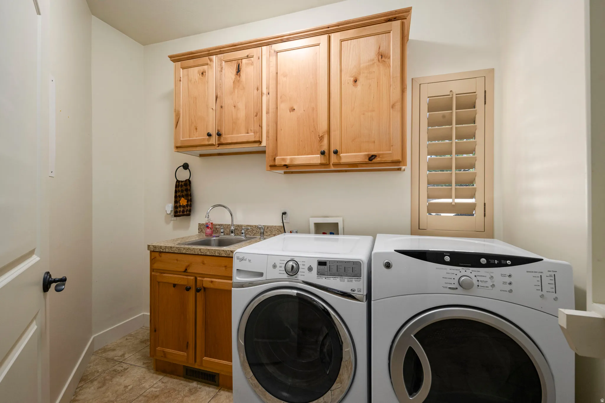 Laundry room featuring cabinet space, washer and dryer, and light tile patterned flooring