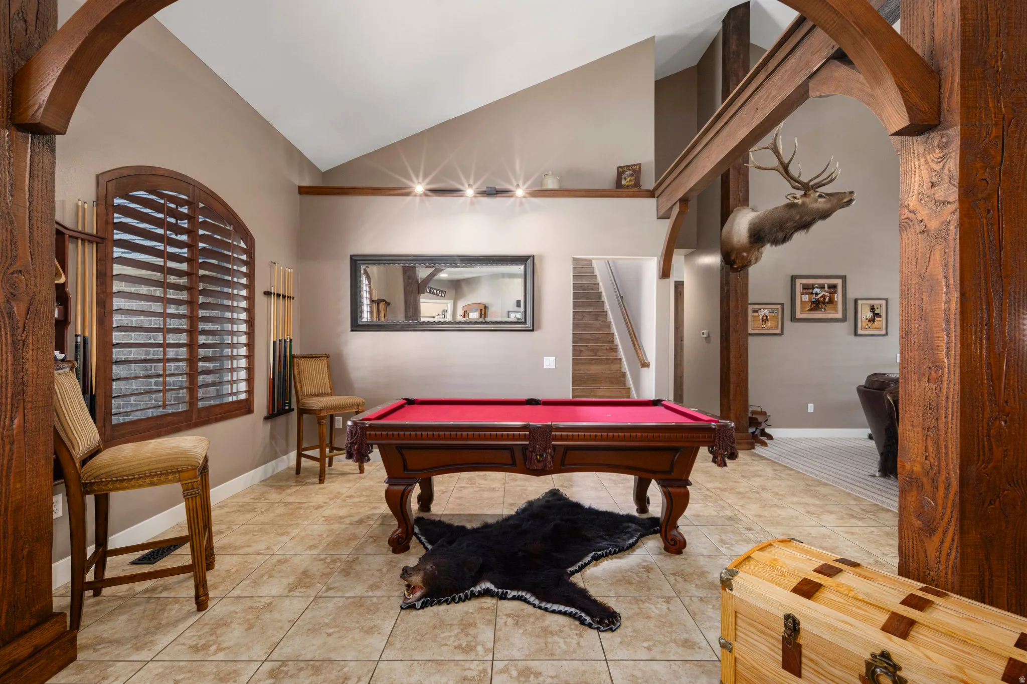Rec room featuring arched walkways, vaulted ceiling, light tile patterned floors, and billiards