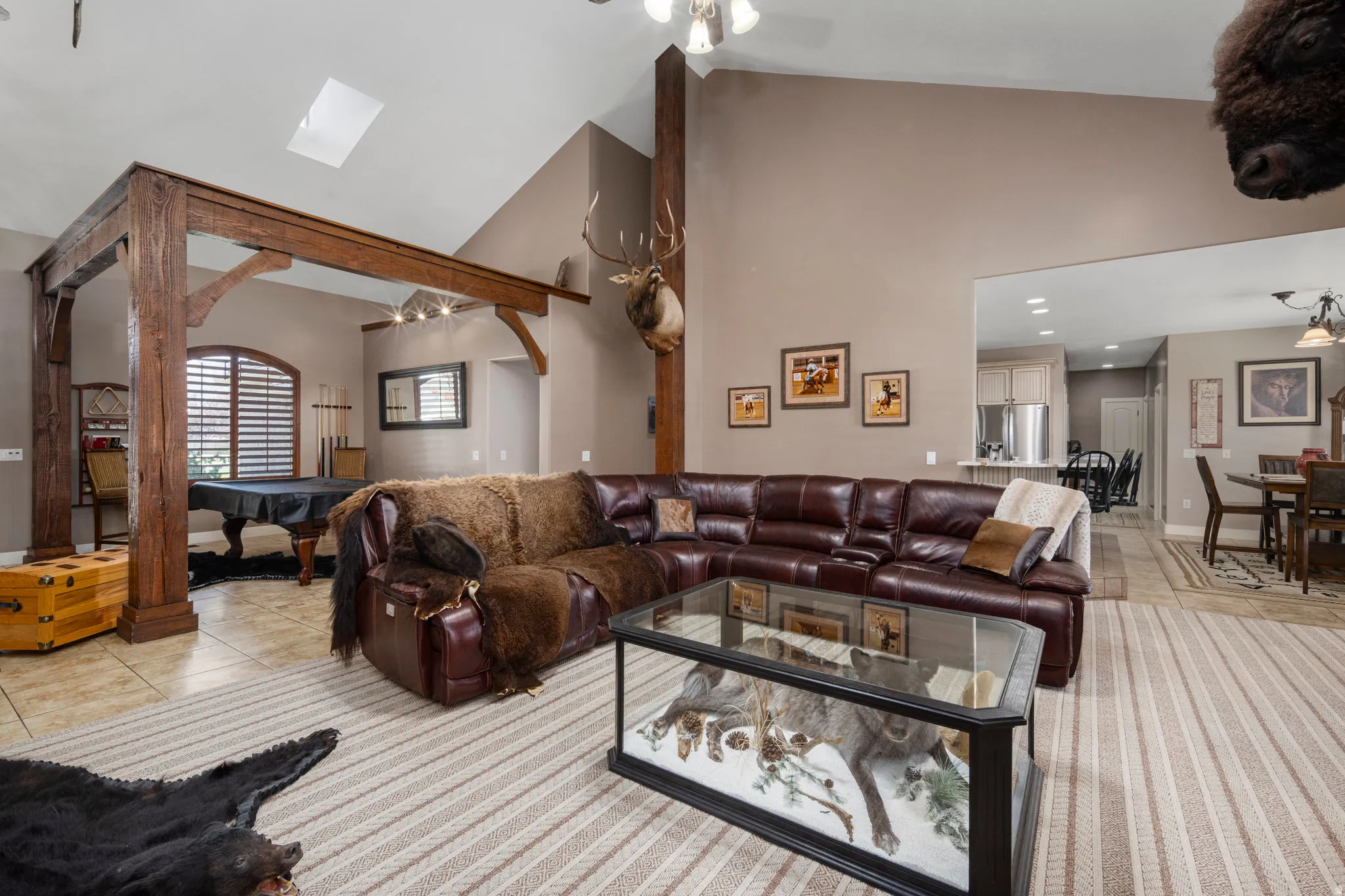 Living area featuring ceiling fan, lofted ceiling, light tile patterned floors, and billiards table