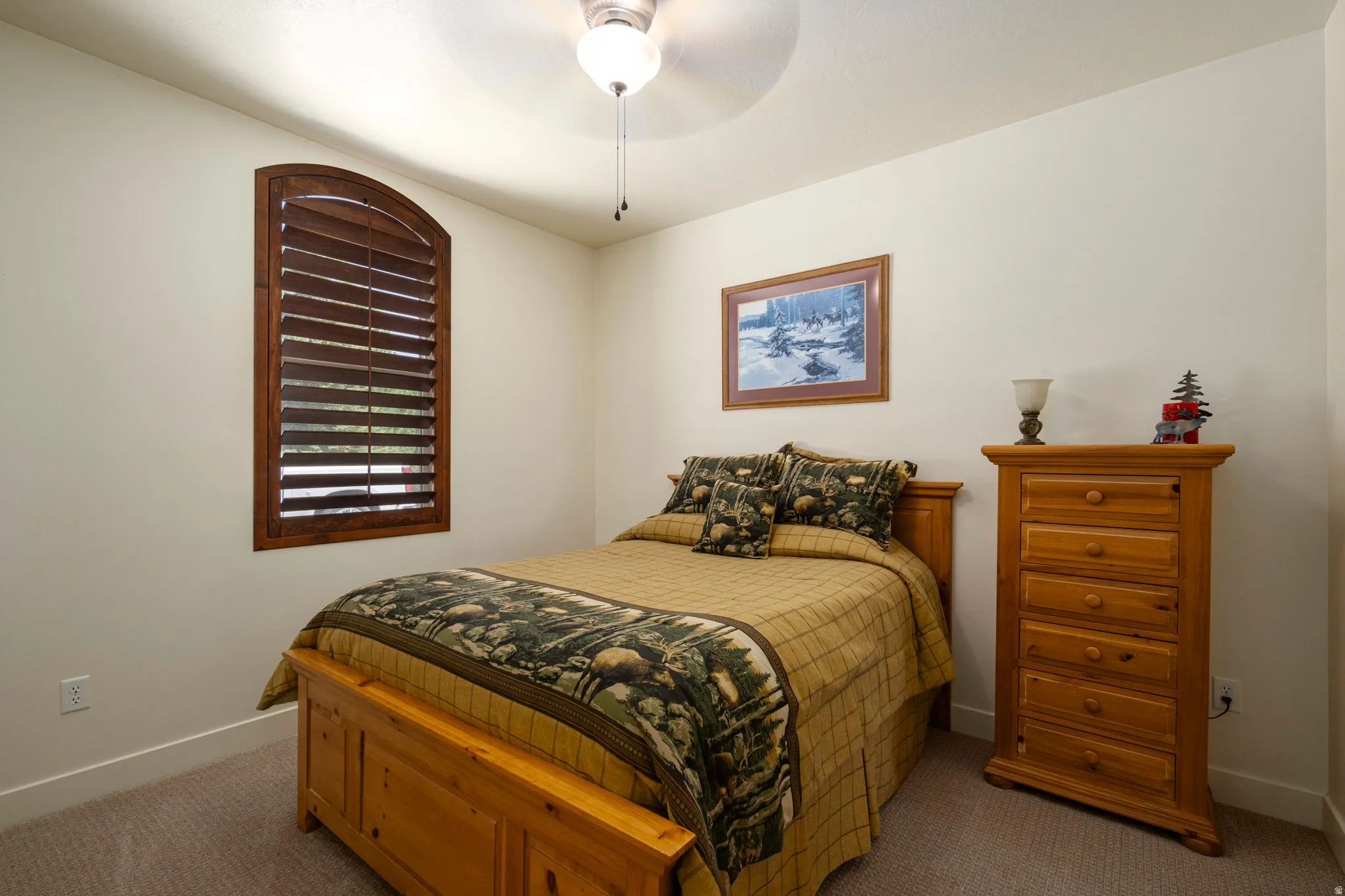 Carpeted bedroom featuring baseboards and ceiling fan