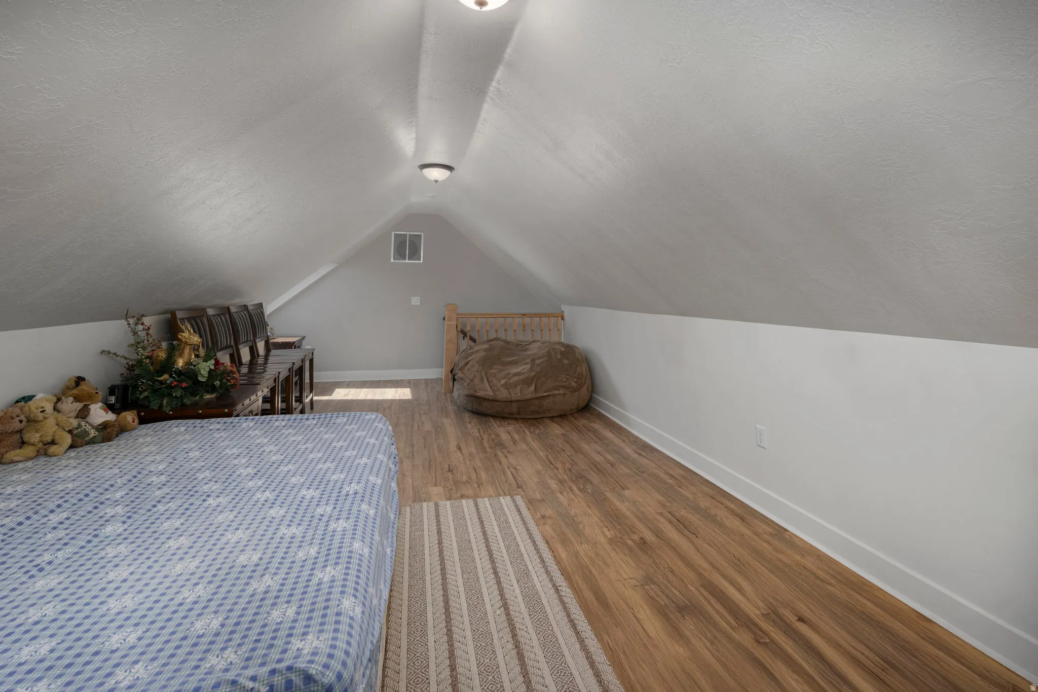 Bedroom featuring wood finished floors and a textured ceiling