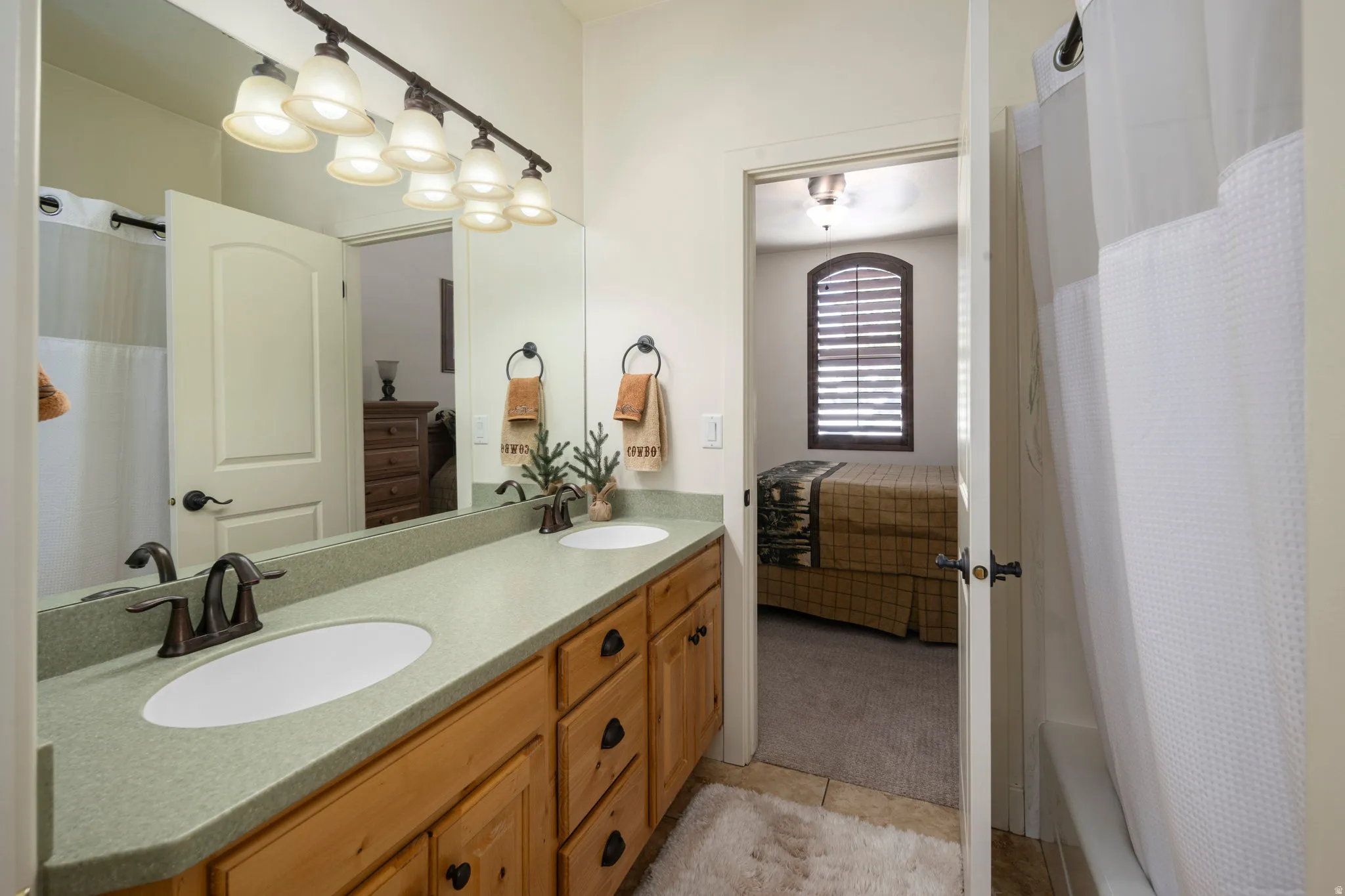 Full bathroom featuring double vanity, ensuite bathroom, and light tile patterned floors