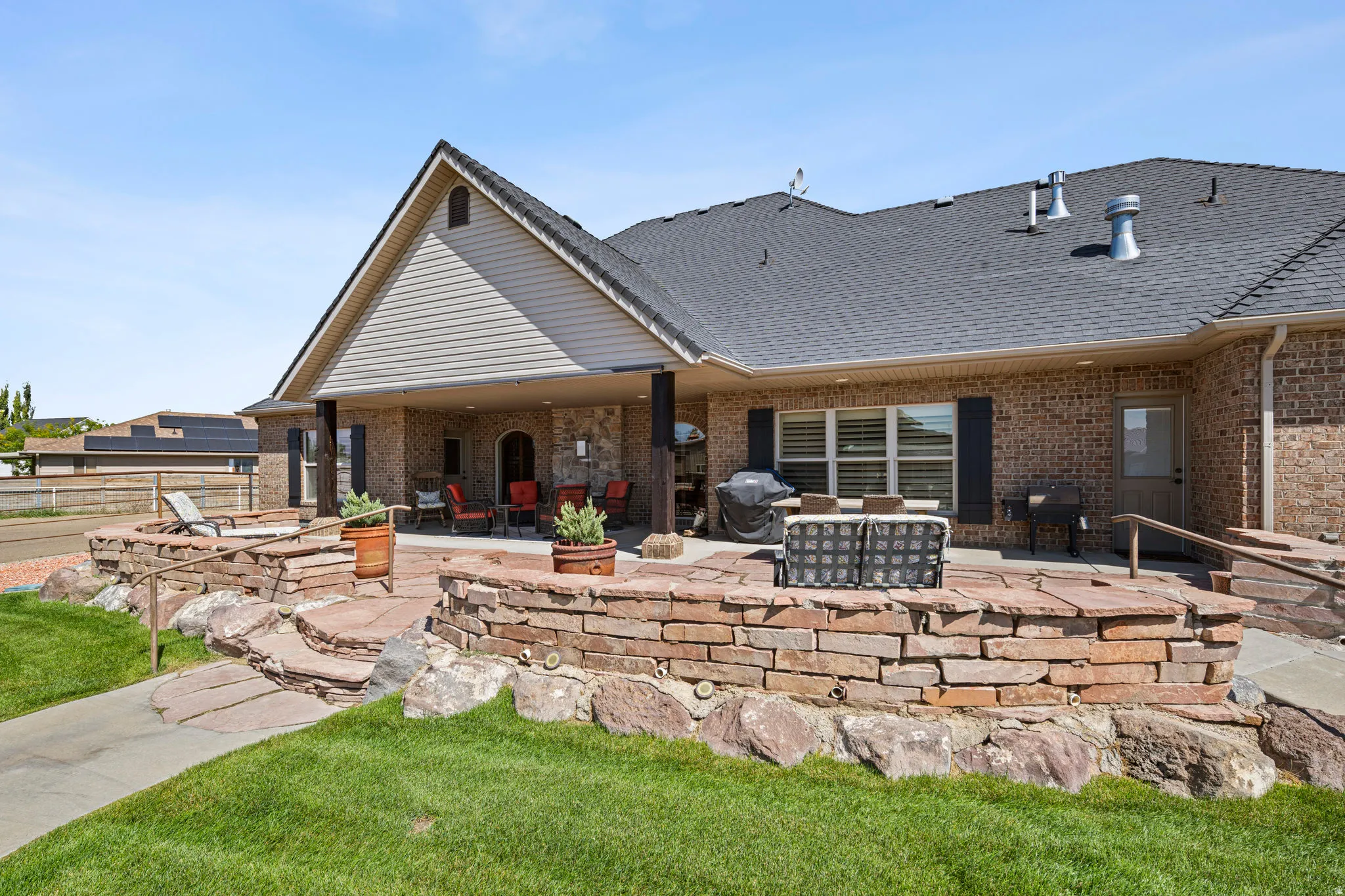 Back of house with a patio, a shingled roof, and brick siding