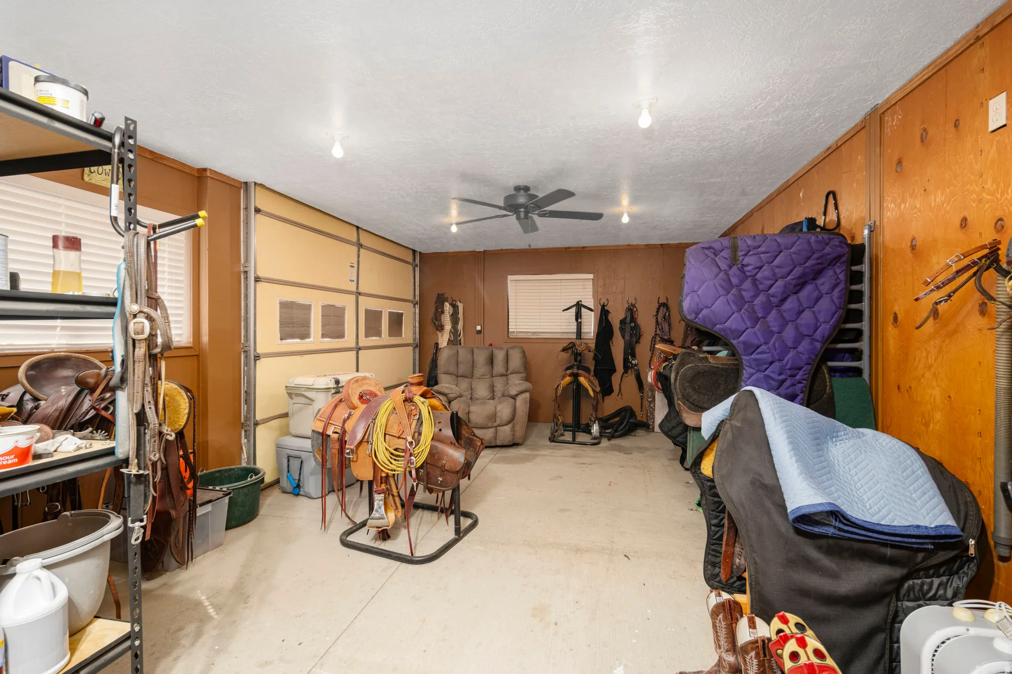 Garage with a ceiling fan and wood walls