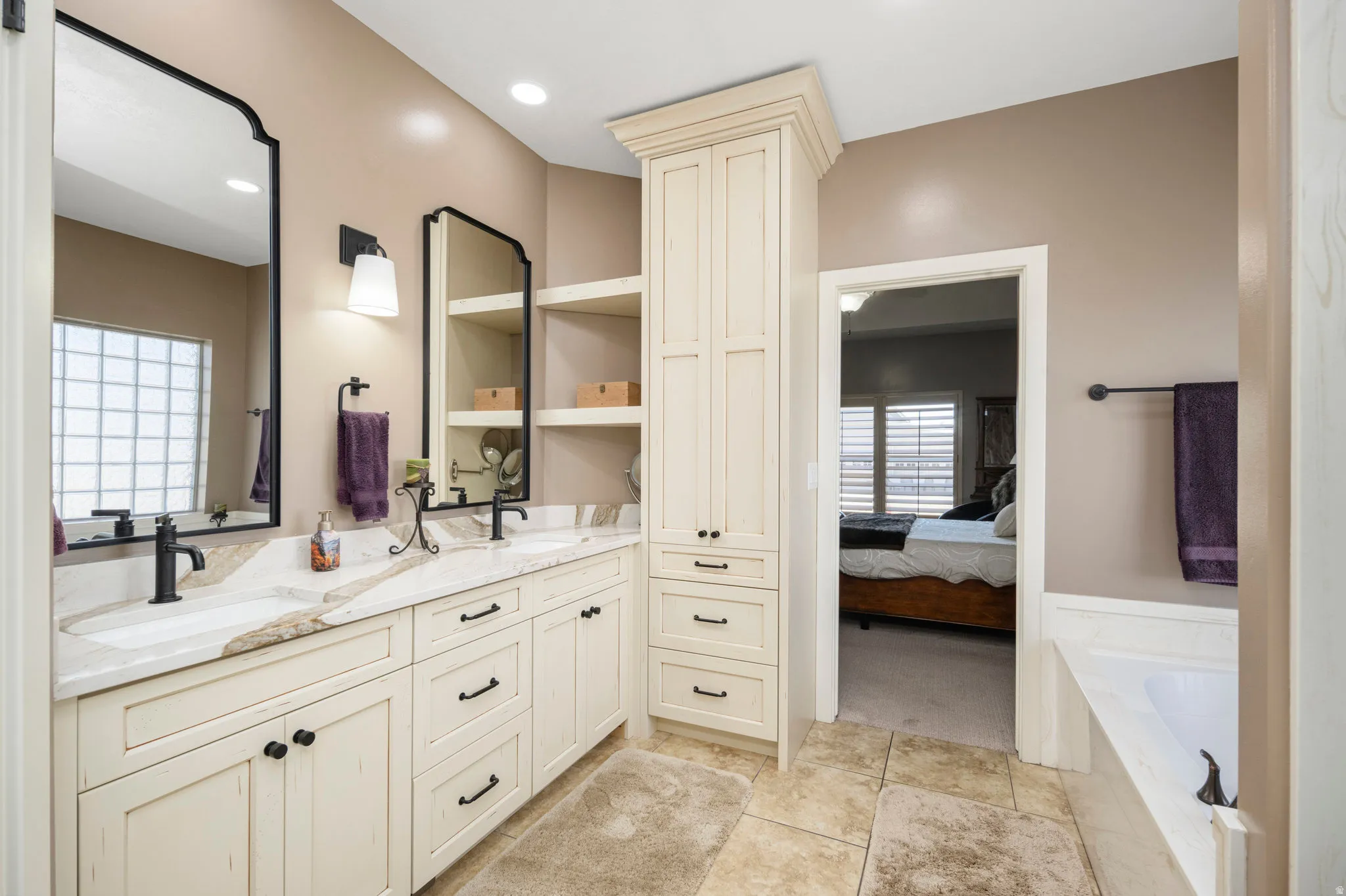 Bathroom featuring ensuite bathroom, double vanity, a garden tub, plenty of natural light, and recessed lighting