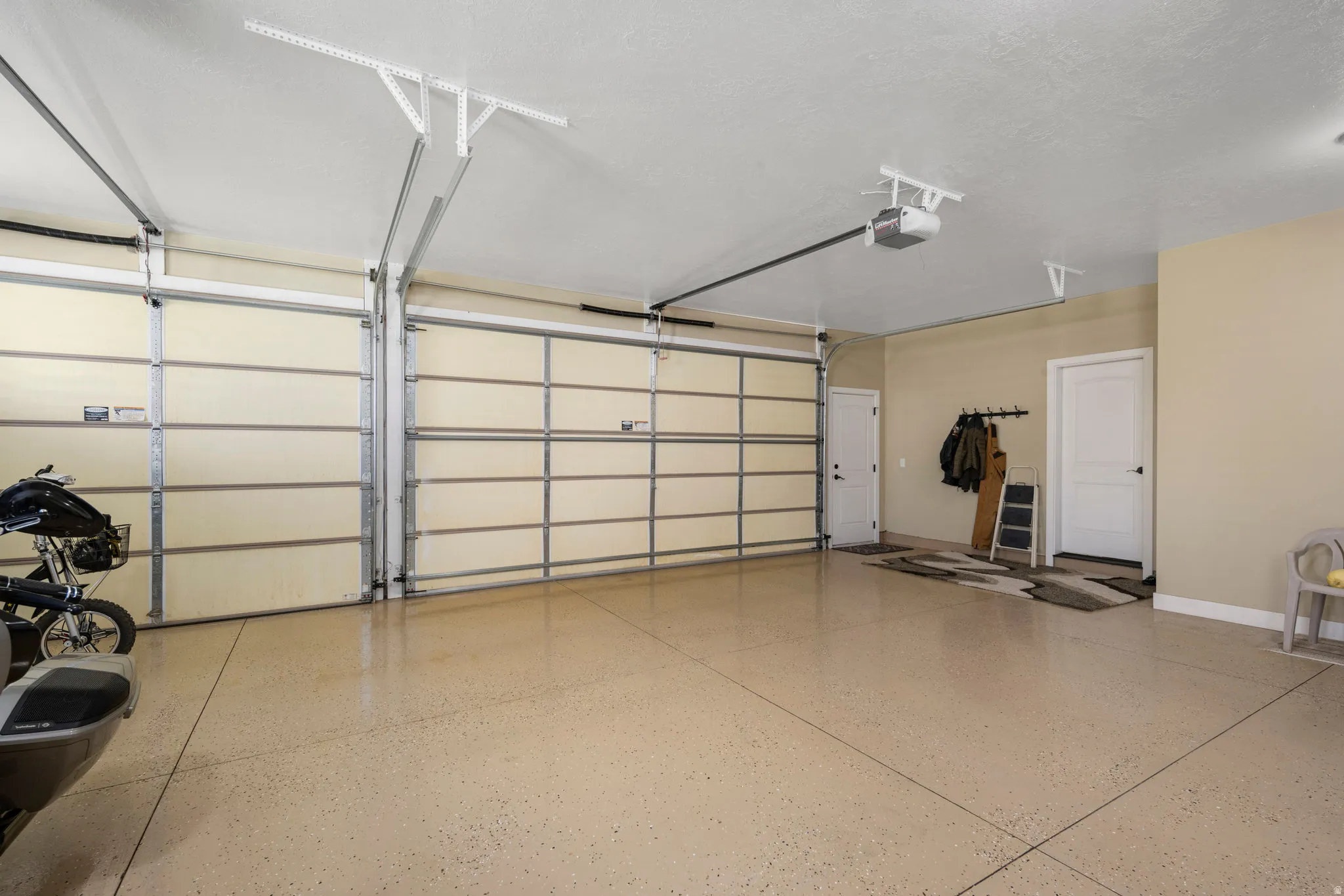 Garage featuring baseboards and a garage door opener
