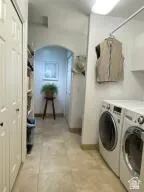Laundry area featuring arched walkways and washer and dryer