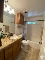 Full bath featuring shower / bathtub combination with curtain and vanity