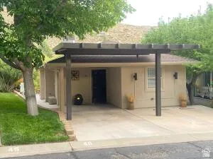 View of front facade featuring stucco siding and an attached carport