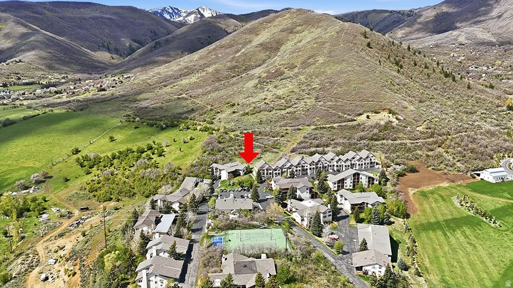 Midway condo for sale aerial with trail system, green space, and mountain views in background. Highlights the connection between the community and nearby trails.