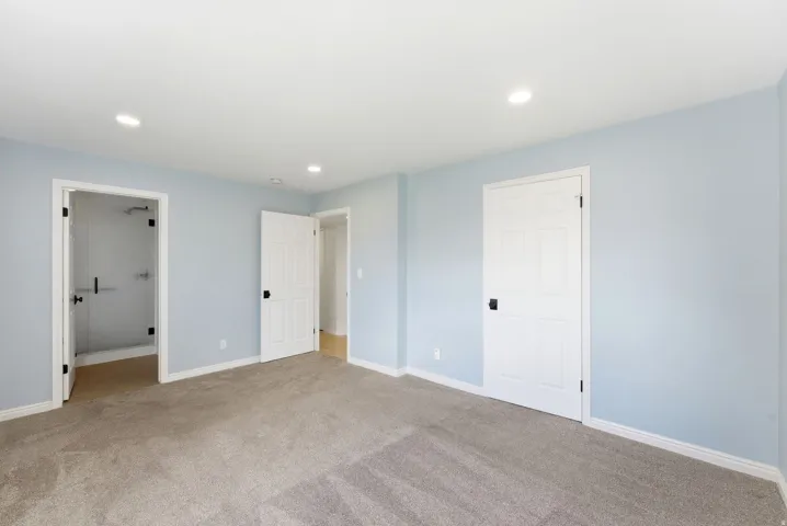 Swiss Oaks primary bedroom with carpet flooring, closet storage, and bright window exposure